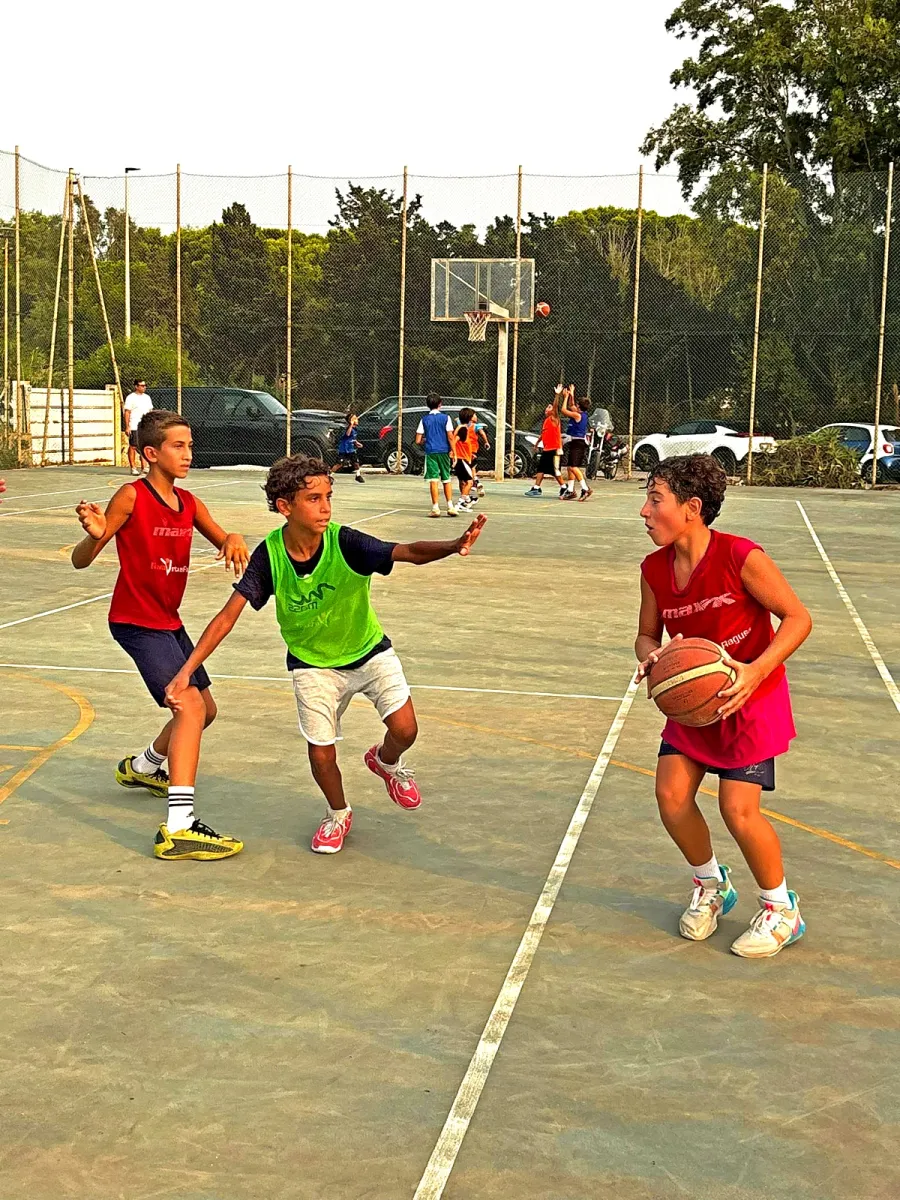 Una giocatrice protegge il pallone mentre due avversari le si fanno incontro.